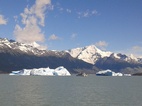 Catamaran empequeñecido entre dos enormes icebergs